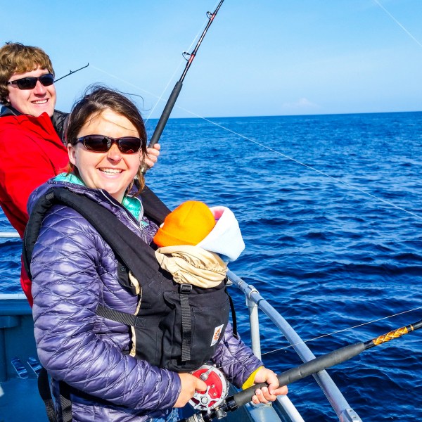 a man riding on the back of a boat in a body of water