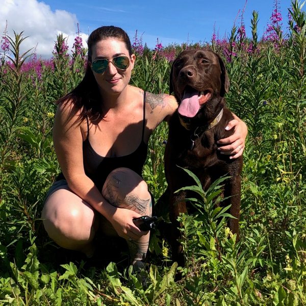 a woman holding a dog posing for the camera