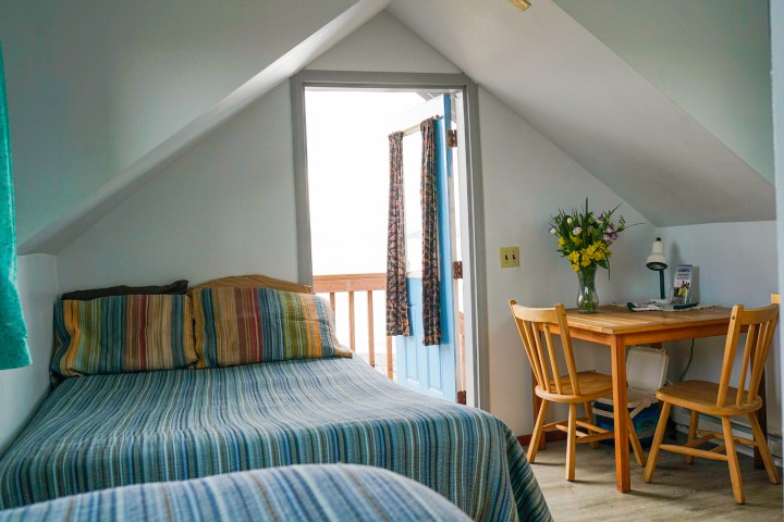 a bedroom with a bed and a chair in a room