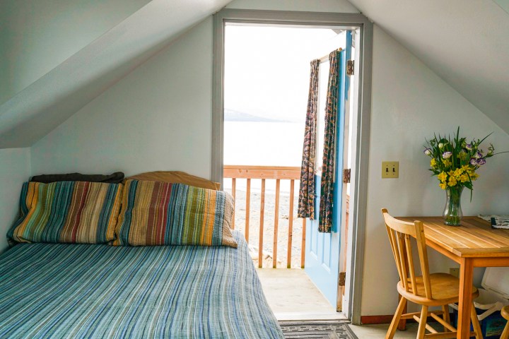 a bedroom with a bed and a chair in a room